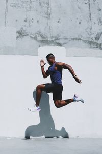 Full length of man jumping by wall