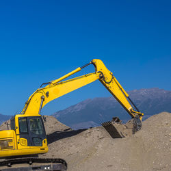 Information sign at construction site against clear blue sky