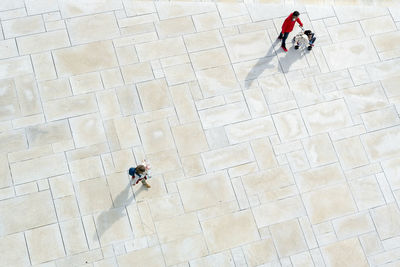 High angle view of people walking on tiled floor