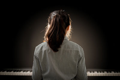 Rear view of woman sitting on stage