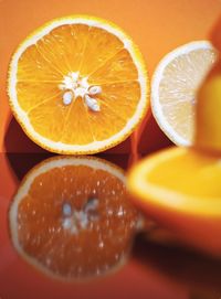 Closeup shot of sliced oranges reflected in glass surface with