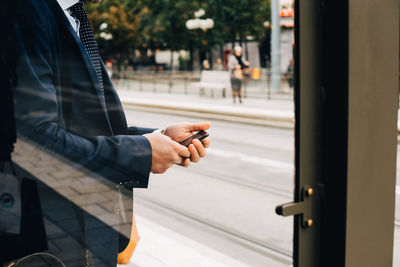 Man holding mobile phone at bus
