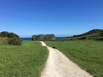 Scenic view of field against clear blue sky