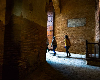 Rear view of people walking on building