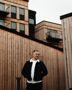 Young man standing against building in city