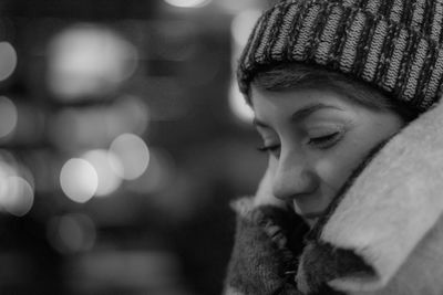 Close-up of young woman with eyes closed at night
