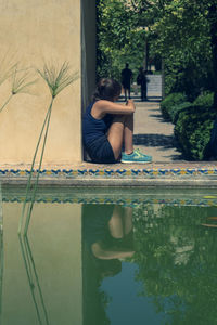 Man sitting by swimming pool in lake