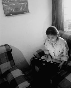 Young woman using mobile phone at home