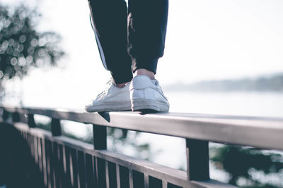 Low section of person standing on railing