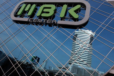 Low angle view of store sign on modern building with reflection