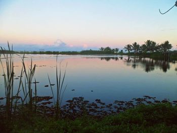 Scenic view of lake against sky at sunset