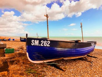 Boats moored on beach against sky