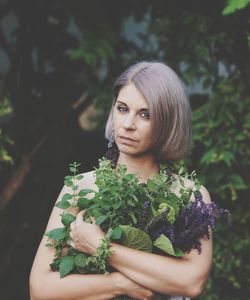 Portrait of young woman with plants