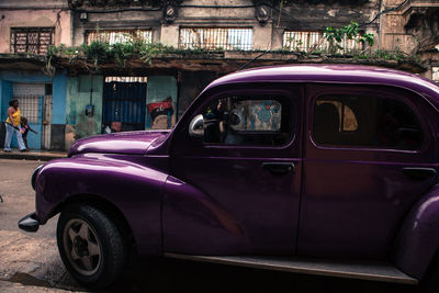 Purple vintage car parked on roadside