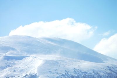 Low angle view of snowcapped mountains against sky