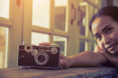 Portrait of woman photographing with camera on table