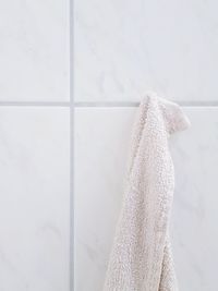 Towel hanging on tiled wall in bathroom