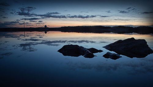 Scenic view of lake against sky at sunset