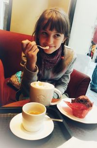 Portrait of a girl sitting on table in restaurant