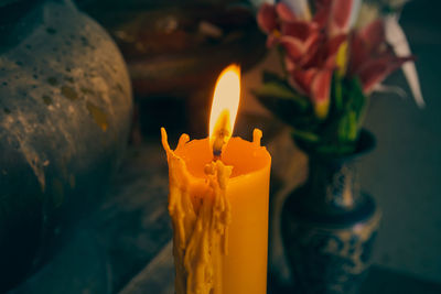 Large yellow candle and fire with flower background in vintage tone