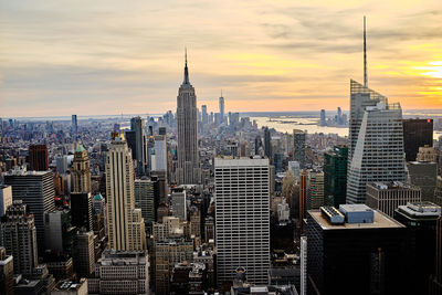 Modern buildings in city against cloudy sky