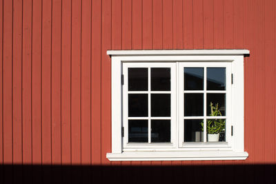 Close-up of window on red wall 