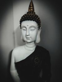 Close-up of buddha statue against wall