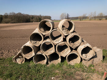 Stack of hay bales on field against sky