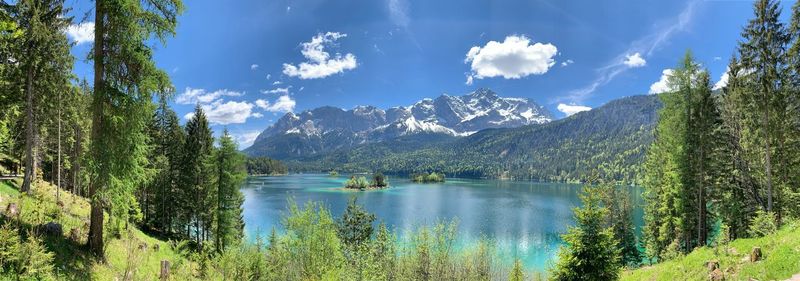 Panoramic view of lake by trees against sky