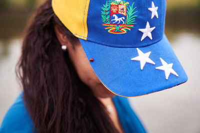 Close-up portrait of woman against blue wall