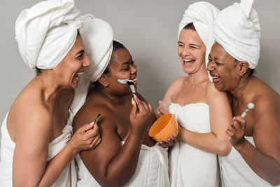 Portrait of female friends giving medicine to daughter