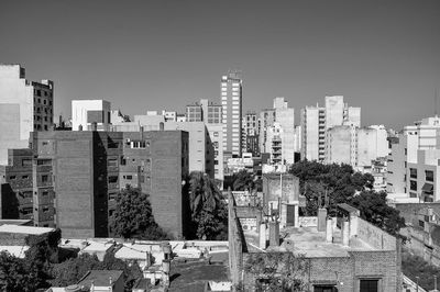 Buildings in city against clear sky