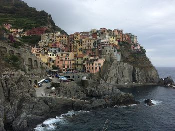 Panoramic view of sea by cliff against sky