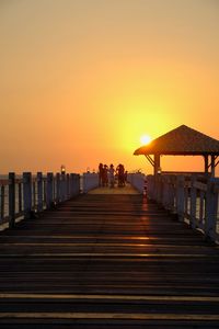 People on beach against orange sky