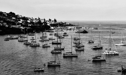 High angle view of sailboats in sea against buildings in city