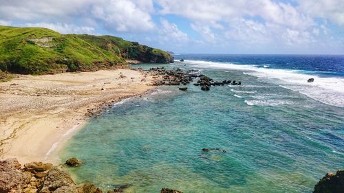 Scenic view of beach against cloudy sky