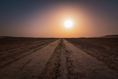 Scenic view of land against clear sky during sunset