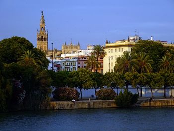 View of church at waterfront against blue sky