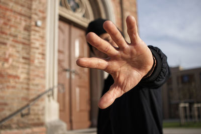 Midsection of person hand on wall