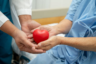 Doctor give red heart to asian senior or elderly old lady woman patient 