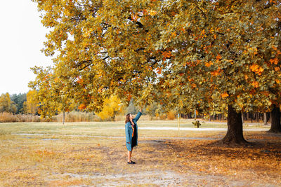 Rear view of woman walking on field