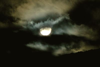 Low angle view of moon against cloudy sky