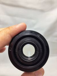 Close-up of cropped hand holding camera lens