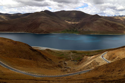 Scenic view of lake and mountains against cloudy sky