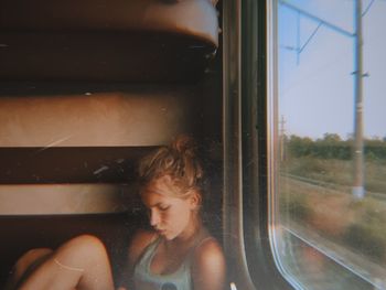 PORTRAIT OF WOMAN LOOKING THROUGH WINDOW