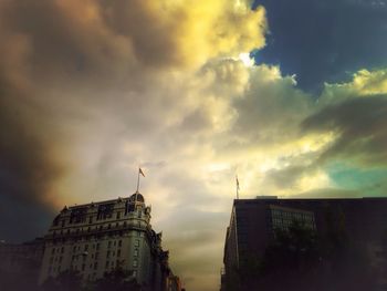 Low angle view of buildings against cloudy sky