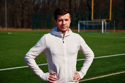 Caucasian man at stadium track preparing for fitness exercises, helathy lifestyle