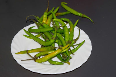 High angle view of green chili pepper against black background