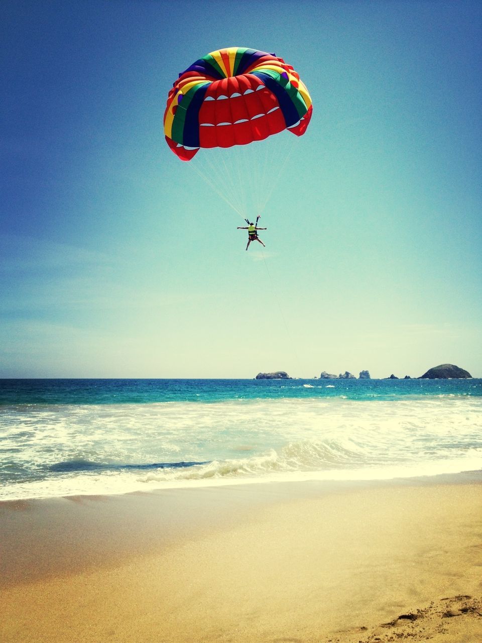 sea, beach, flying, parachute, mid-air, clear sky, extreme sports, sand, horizon over water, blue, paragliding, adventure, transportation, water, vacations, scenics, sport, shore, leisure activity, copy space