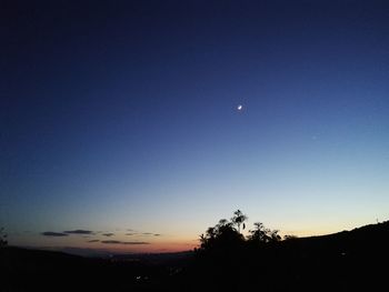 Silhouette landscape against sky at night
